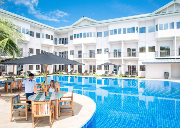 Cove resort view of pool with hotel in background and people sitting at the pool bar